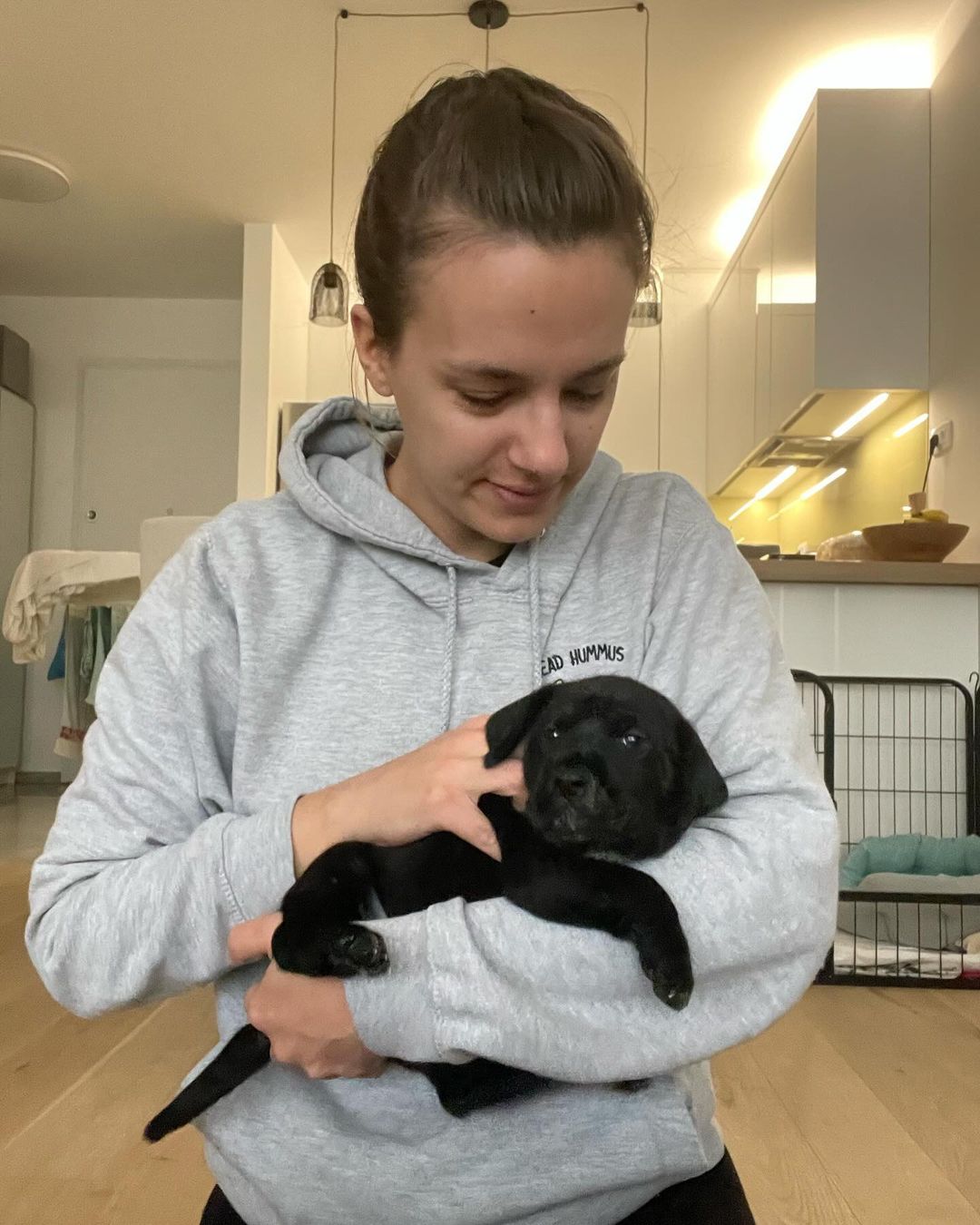 woman holding black puppy